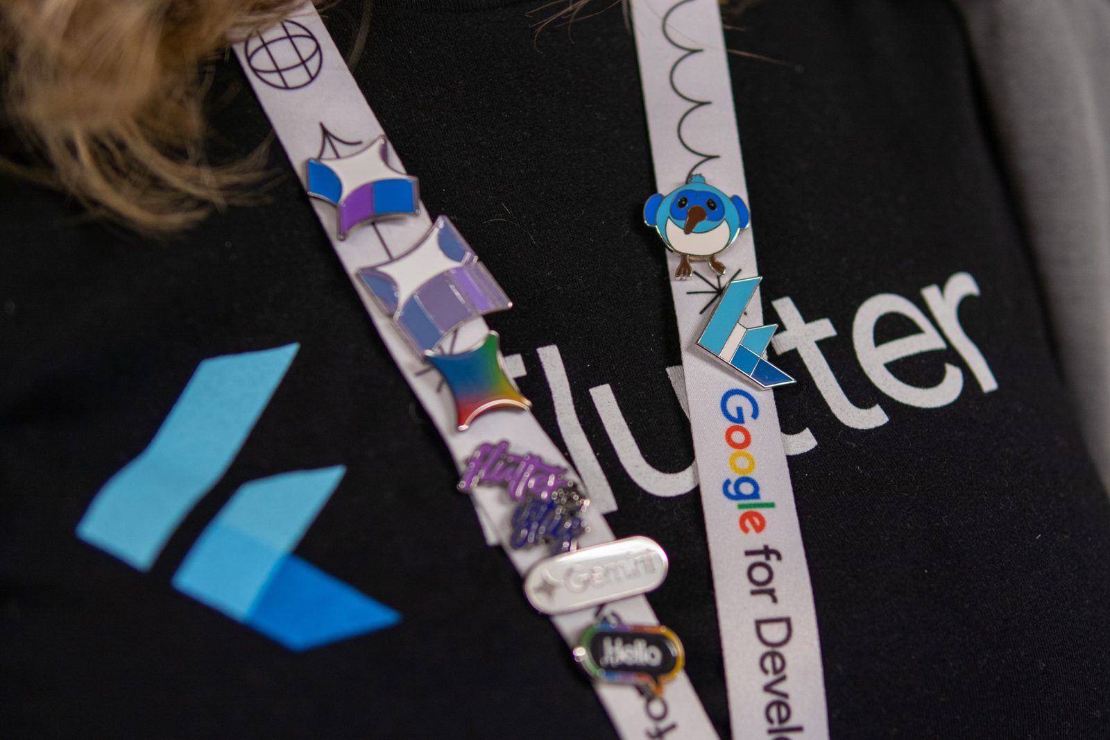 Flutter and Gemini pins on a lanyard